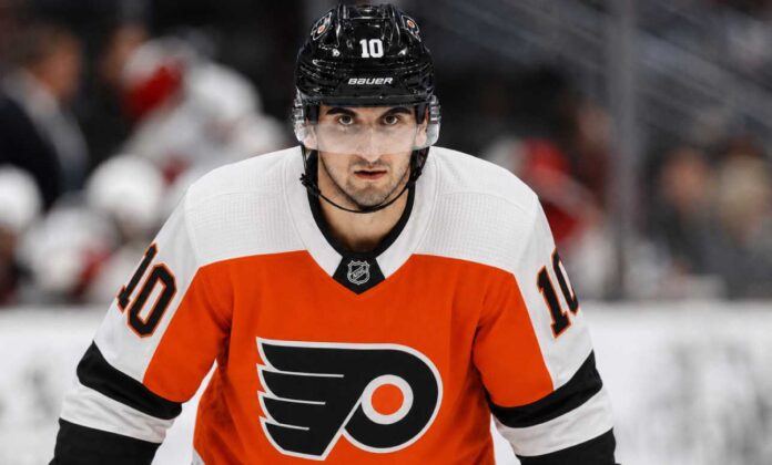 Matty Beniers wearing a Philadelphia Flyers home jersey and helmet amid NHL trade rumors linking the Seattle Kraken center to Philadelphia.