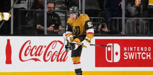 Mitch Marner celebrates for the Vegas Golden Knights beside Coca-Cola and Nintendo Switch board ads in a 2026-27 fantasy hockey projection.