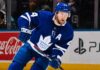Morgan Rielly skating in a Toronto Maple Leafs home jersey as trade rumors suggest the veteran defenseman could remain in Toronto for the 2026-27 NHL season.