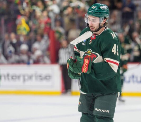 Quinn Hughes in a Minnesota Wild jersey during contract extension rumors involving a potential $17 million to $18 million annual salary