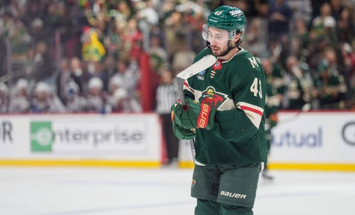 quinn-hughes-minnesota-wild-contract-extension-rumor Quinn Hughes in a Minnesota Wild jersey during contract extension rumors involving a potential $17 million to $18 million annual salary
