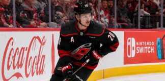 Sebastian Aho skating for the Carolina Hurricanes as a left-shot beside Coca-Cola and Nintendo Switch ads in a 2026-27 fantasy hockey projection