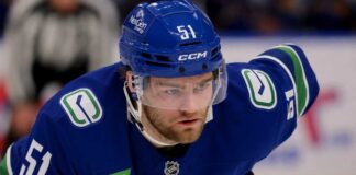 Shane Wright wearing a Vancouver Canucks home jersey amid trade rumors involving the Seattle Kraken.