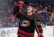 Simon Edvinsson wearing a Carolina Hurricanes home jersey amid offer-sheet rumors involving the Detroit Red Wings.