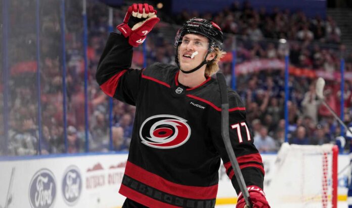simon-edvinsson-carolina-hurricanes-offer-sheet-rumor Simon Edvinsson wearing a Carolina Hurricanes home jersey amid offer-sheet rumors involving the Detroit Red Wings.