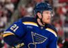 Alexander Nikishin wearing a St. Louis Blues home jersey amid NHL trade rumors involving the Carolina Hurricanes