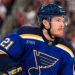 Alexander Nikishin wearing a St. Louis Blues home jersey amid NHL trade rumors involving the Carolina Hurricanes