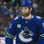 Vancouver Canucks Interested in Shane Wright, but Seattle Kraken Set Enormous Trade Price Shane Wright wearing a Vancouver Canucks home jersey amid trade rumors involving the Seattle Kraken, Zeev Buium and Tom Willander.