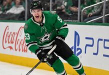 Wyatt Johnston Point Projections 2026-27: Can the Dallas Stars Star Reach 90 Points Again? Wyatt Johnston skating in a Dallas Stars home jersey beside Coca-Cola and PS5 ads for his 2026-27 fantasy hockey point projection.