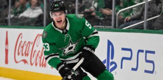 Wyatt Johnston skating in a Dallas Stars home jersey beside Coca-Cola and PS5 ads for his 2026-27 fantasy hockey point projection.