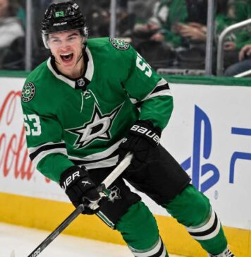 Wyatt Johnston Point Projections 2026-27: Can the Dallas Stars Star Reach 90 Points Again? Wyatt Johnston skating in a Dallas Stars home jersey beside Coca-Cola and PS5 ads for his 2026-27 fantasy hockey point projection.