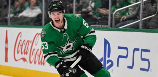 Wyatt Johnston Point Projections 2026-27: Can the Dallas Stars Star Reach 90 Points Again? Wyatt Johnston skating in a Dallas Stars home jersey beside Coca-Cola and PS5 ads for his 2026-27 fantasy hockey point projection.