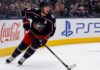 Zach Werenski Point Projections 2026-27: Columbus Blue Jackets Fantasy Outlook Zach Werenski skating left-handed for the Columbus Blue Jackets beside Coca-Cola and PS5 board ads during a 2026-27 fantasy hockey projection