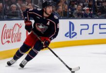 Zach Werenski Point Projections 2026-27: Columbus Blue Jackets Fantasy Outlook Zach Werenski skating left-handed for the Columbus Blue Jackets beside Coca-Cola and PS5 board ads during a 2026-27 fantasy hockey projection
