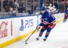 Alexis Lafreniere Point Projections 2026-27: New York Rangers Fantasy Outlook Alexis Lafreniere skating for the New York Rangers beside Coca-Cola and PS5 board ads in a 2026-27 Fantasy Hockey projection