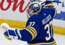 Connor Hellebuyck pictured in a Buffalo Sabres home jersey and goalie equipment amid trade rumors linking the Winnipeg Jets star to Buffalo.
