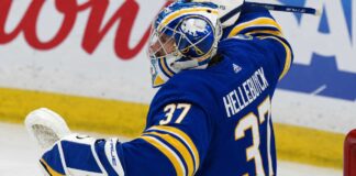 Connor Hellebuyck pictured in a Buffalo Sabres home jersey and goalie equipment amid trade rumors linking the Winnipeg Jets star to Buffalo.