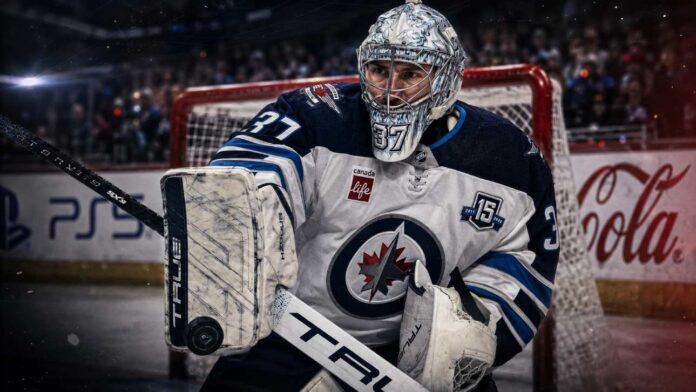 connor-hellebuyck-winnipeg-jets-trade-rumors-holdout-2026 Connor Hellebuyck in a Winnipeg Jets uniform as NHL trade rumors grow over a possible training camp holdout and blockbuster trade.