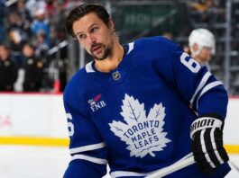 Erik Karlsson wearing a Toronto Maple Leafs home jersey amid NHL trade rumors linking the Pittsburgh Penguins defenseman to Toronto