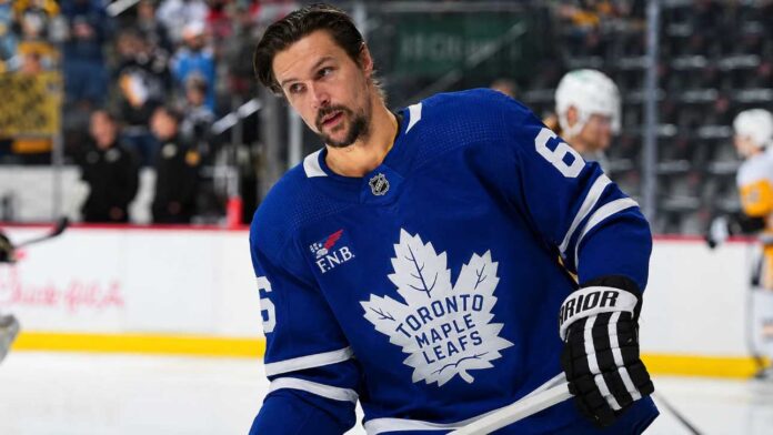 Erik Karlsson wearing a Toronto Maple Leafs home jersey amid NHL trade rumors linking the Pittsburgh Penguins defenseman to Toronto