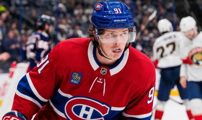 kent-johnson-canadiens-blue-jackets-trade-rumor Kent Johnson wearing a Montreal Canadiens home jersey and helmet amid trade rumors linking him to the Canadiens