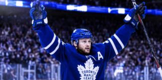 Morgan Rielly celebrates in a Toronto Maple Leafs jersey amid NHL trade rumors about his future in Toronto.