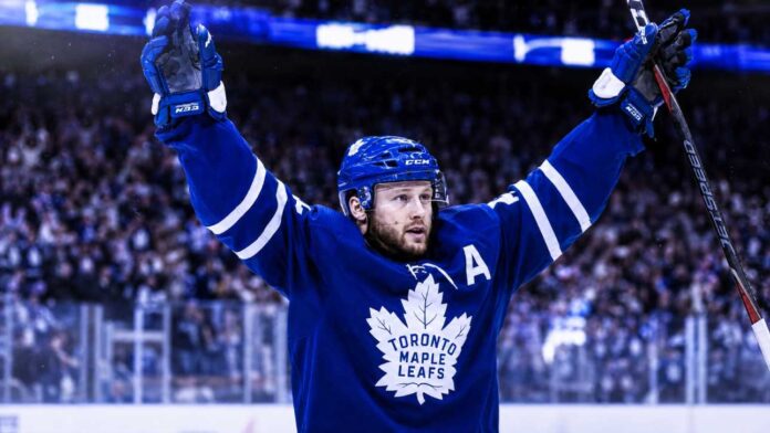 morgan-rielly-toronto-maple-leafs-trade-rumors Morgan Rielly celebrates in a Toronto Maple Leafs jersey amid NHL trade rumors about his future in Toronto.