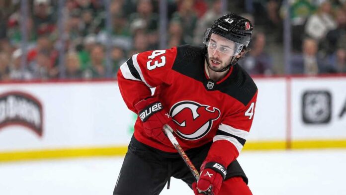 quinn-hughes-devils-wild-contract-rumor-2027 Quinn Hughes wearing a New Jersey Devils home jersey in a concept image tied to his potential 2027 NHL free-agent move from the Minnesota Wild