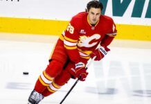 Is Zach Whitecloud on the Trade Block? Calgary Flames Face an Interesting Decision Calgary Flames defenseman Zach Whitecloud skates in a red Flames jersey amid NHL trade rumors linking him to a possible move.