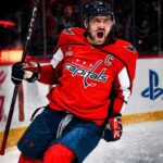 Alex Ovechkin Point Projections 2026-27: Washington Capitals Fantasy Outlook Alex Ovechkin celebrating for the Washington Capitals beside Coca-Cola and PS5 board ads in a 2026-27 fantasy hockey point projection.