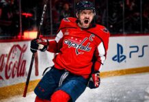 Alex Ovechkin Point Projections 2026-27: Washington Capitals Fantasy Outlook Alex Ovechkin celebrating for the Washington Capitals beside Coca-Cola and PS5 board ads in a 2026-27 fantasy hockey point projection.
