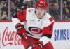 Alexander Nikishin Trade Rumors: Did His Hurricanes Camp Absence Just Force Carolina’s Hand? Alexander Nikishin of the Carolina Hurricanes skates with the puck during game action with Coca-Cola and Samsung ads on the boards in the background