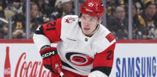 Alexander Nikishin Trade Rumors: Did His Hurricanes Camp Absence Just Force Carolina’s Hand? Alexander Nikishin of the Carolina Hurricanes skates with the puck during game action with Coca-Cola and Samsung ads on the boards in the background