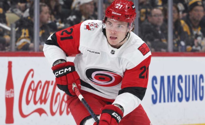 alexander-nikishin-carolina-hurricanes-trade-rumors Alexander Nikishin of the Carolina Hurricanes skates with the puck during game action with Coca-Cola and Samsung ads on the boards in the background
