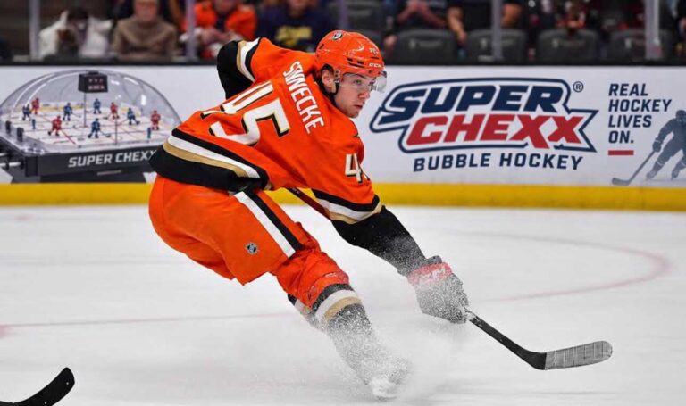 Beckett Sennecke of the Anaheim Ducks skates with the puck during game action beside a Super Chexx Bubble Hockey board ad in a 2026-27 fantasy hockey projection post