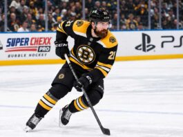 Filip Hronek in a Boston Bruins home jersey skates during a concept image as Boston Bruins trade rumors link the Vancouver Canucks defenceman to Boston.