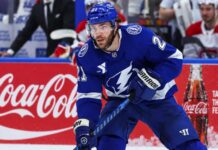 Tampa Bay Lightning forward skating on the ice in front of a stylish Coca-Cola boards ad in a Brayden Point fantasy hockey projection post