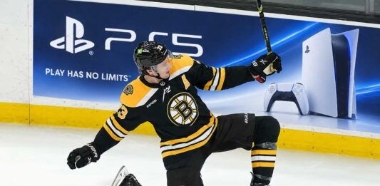 Charlie McAvoy of the Boston Bruins celebrates on the ice during a game as his 2026-27 fantasy hockey projection highlights his scoring upside and power-play value.