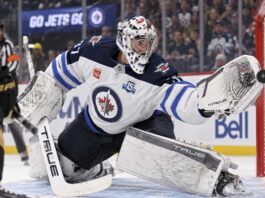 Connor Hellebuyck of the Winnipeg Jets makes a save against the Vegas Golden Knights amid NHL trade rumors linking him to Montreal.