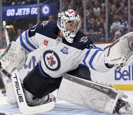 Connor Hellebuyck of the Winnipeg Jets makes a save against the Vegas Golden Knights amid NHL trade rumors linking him to Montreal.