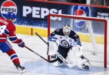 Connor Hellebuyck Trade Rumors: Did His Canadiens Decision Just Open the Door to a Blockbuster? Nick Suzuki of the Montreal Canadiens attacks the net against Winnipeg Jets goalie Connor Hellebuyck amid NHL trade rumors linking Hellebuyck to Montreal.