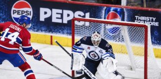 Connor Hellebuyck Trade Rumors: Did His Canadiens Decision Just Open the Door to a Blockbuster? Nick Suzuki of the Montreal Canadiens attacks the net against Winnipeg Jets goalie Connor Hellebuyck amid NHL trade rumors linking Hellebuyck to Montreal.