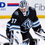 Connor Hellebuyck in a Utah Mammoth uniform and goalie equipment during warmups, illustrating Winnipeg Jets and Utah Mammoth trade rumors