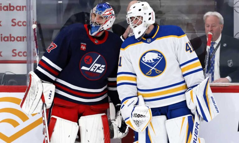 Buffalo Sabres goalie in away uniform beside a Winnipeg Jets goaltender as Connor Hellebuyck trade rumors intensify around the Winnipeg Jets