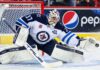 Connor Hellebuyck makes a save for the Winnipeg Jets as trade rumors grow over a possible return to Winnipeg.