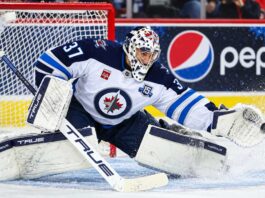 Connor Hellebuyck makes a save for the Winnipeg Jets as trade rumors grow over a possible return to Winnipeg.