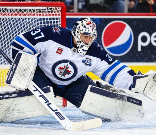 Connor Hellebuyck makes a save for the Winnipeg Jets as trade rumors grow over a possible return to Winnipeg.