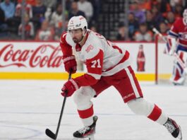 Dylan Larkin of the Detroit Red Wings skates in front of a Montreal Canadiens goalie during NHL trade rumors linking Larkin to Montreal