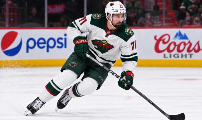 dylan-larkin-red-wings-minnesota-wild-trade-rumors-2026 Dylan Larkin in a Minnesota Wild away uniform concept image amid NHL trade rumors linking the Detroit Red Wings centre to Minnesota.