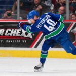Elias Pettersson Trade Rumors: Is the Door Back Open for the Los Angeles Kings? Elias Pettersson of the Vancouver Canucks takes a powerful shot in action as a Super Chexx bubble hockey board ad appears behind him amid Los Angeles Kings trade rumors.